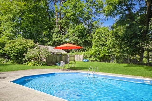 view of swimming pool featuring a lawn