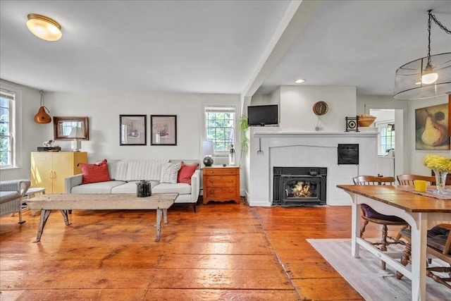 living room featuring a fireplace, hardwood / wood-style floors, and beamed ceiling