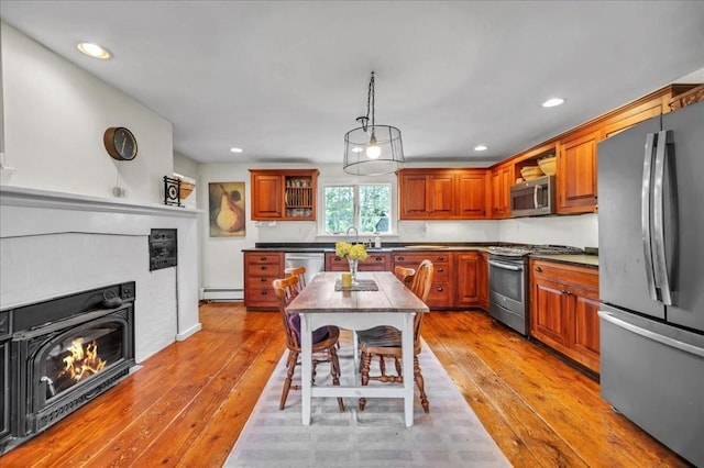 kitchen featuring decorative light fixtures, stainless steel appliances, light hardwood / wood-style flooring, and baseboard heating