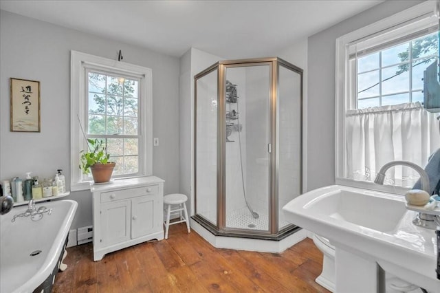 bathroom with hardwood / wood-style floors, shower with separate bathtub, sink, and a wealth of natural light