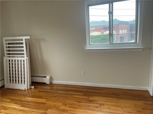 empty room featuring light hardwood / wood-style floors and a baseboard radiator