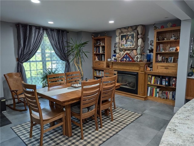 dining space featuring a large fireplace and concrete floors