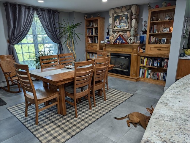 dining space with a fireplace and concrete floors