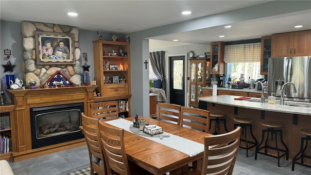 tiled dining area with sink and a fireplace