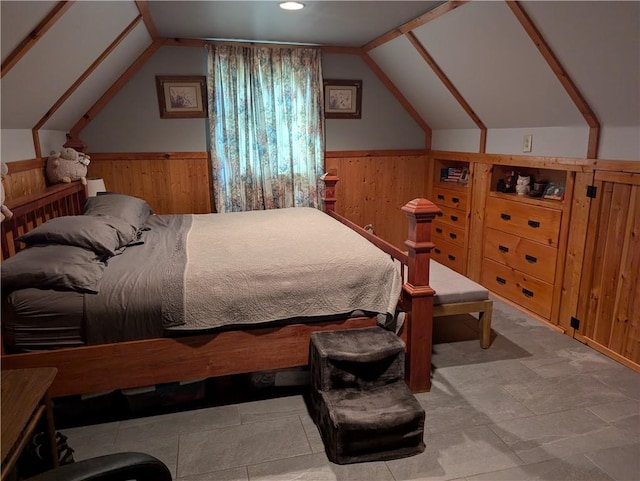 bedroom with lofted ceiling and wood walls