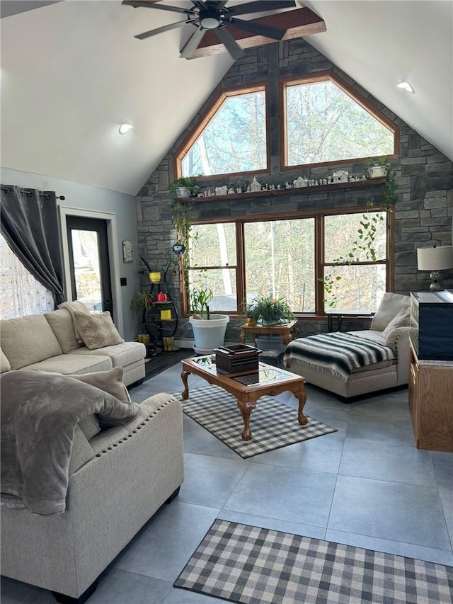 living room with ceiling fan, high vaulted ceiling, and a healthy amount of sunlight