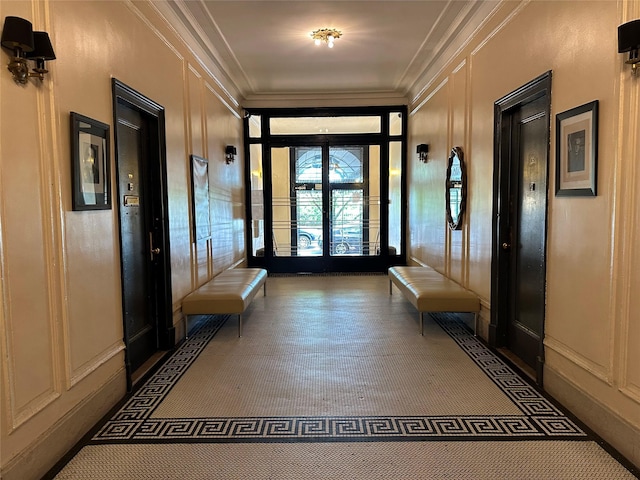 mudroom featuring crown molding, french doors, and a decorative wall