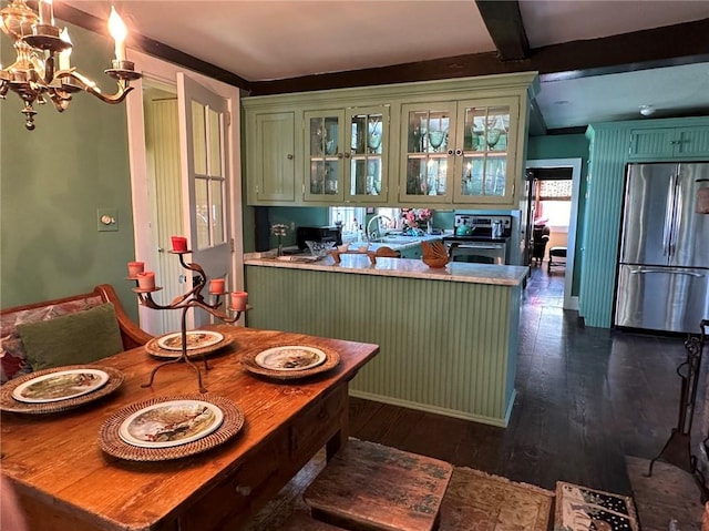 kitchen featuring dark wood-type flooring, green cabinetry, beamed ceiling, kitchen peninsula, and stainless steel appliances