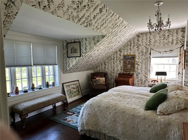 bedroom with dark hardwood / wood-style flooring, vaulted ceiling, and a notable chandelier