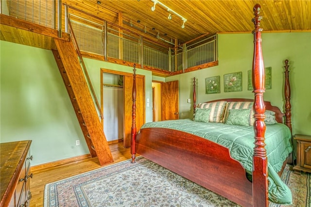 bedroom with wood ceiling, a closet, hardwood / wood-style floors, and vaulted ceiling