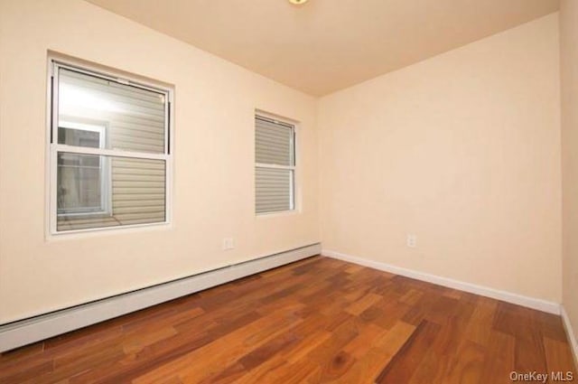 spare room with hardwood / wood-style floors and baseboard heating