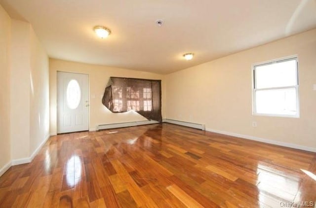 foyer entrance featuring hardwood / wood-style floors and a baseboard heating unit