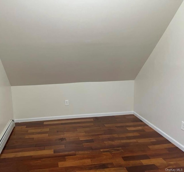 additional living space featuring dark hardwood / wood-style floors, vaulted ceiling, and a baseboard radiator