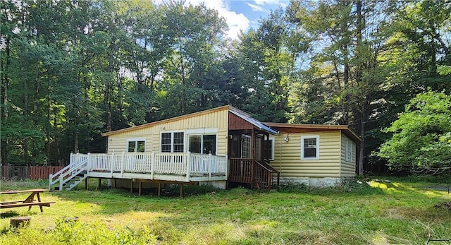 rear view of property with a lawn and a deck