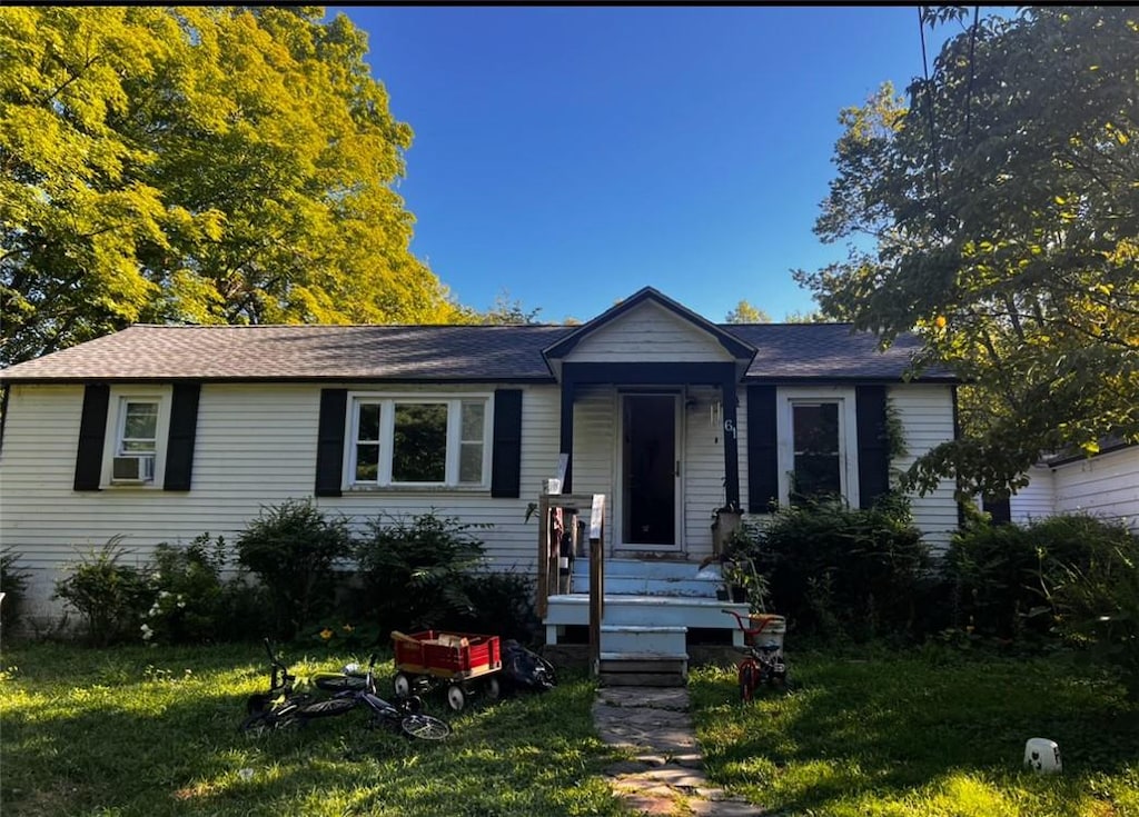 view of front facade with a front lawn and cooling unit