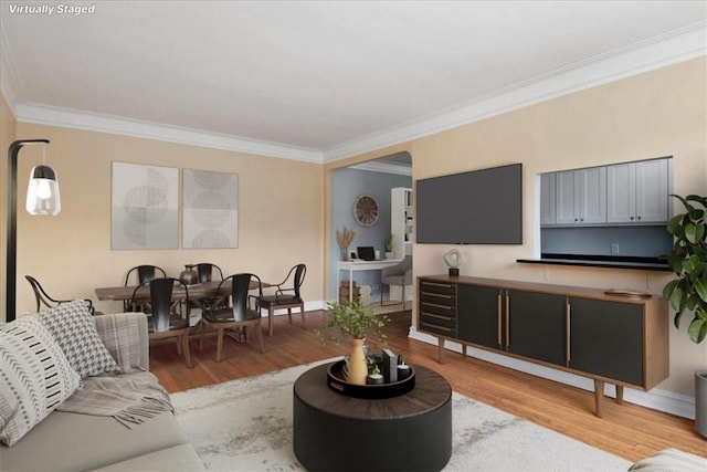 living room with light hardwood / wood-style flooring and crown molding