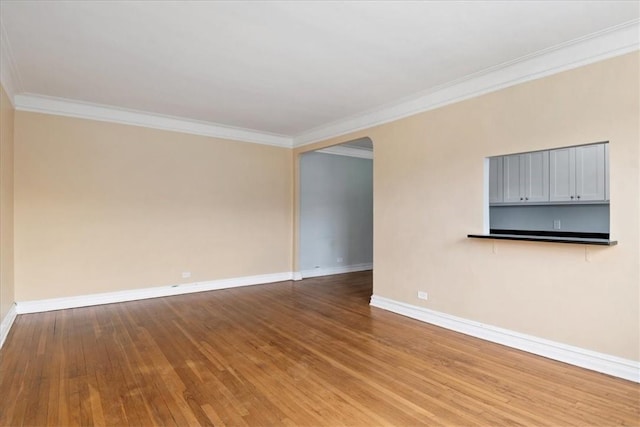 spare room featuring wood-type flooring and ornamental molding