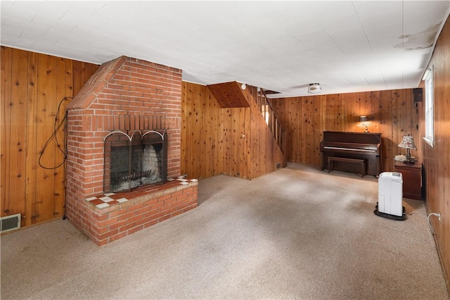 unfurnished living room with wood walls, a fireplace, and carpet