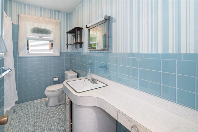 bathroom featuring tile patterned flooring, vanity, tile walls, and toilet