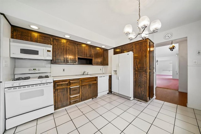 kitchen featuring white appliances, an inviting chandelier, sink, hanging light fixtures, and light tile patterned floors