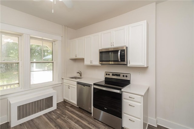 kitchen with dark hardwood / wood-style flooring, white cabinetry, sink, and appliances with stainless steel finishes