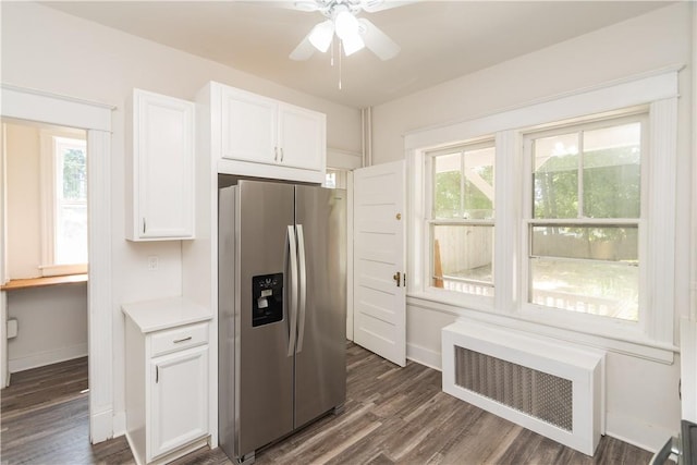 kitchen featuring a healthy amount of sunlight, stainless steel fridge with ice dispenser, dark wood-type flooring, and white cabinetry