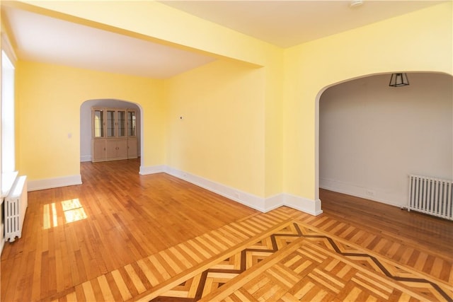 unfurnished room featuring radiator and wood-type flooring