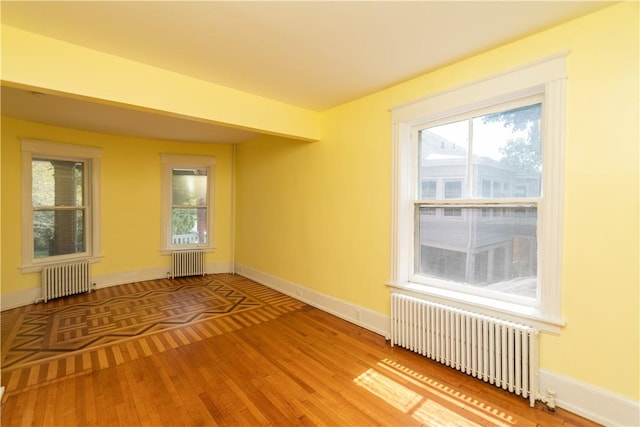 spare room with wood-type flooring and radiator