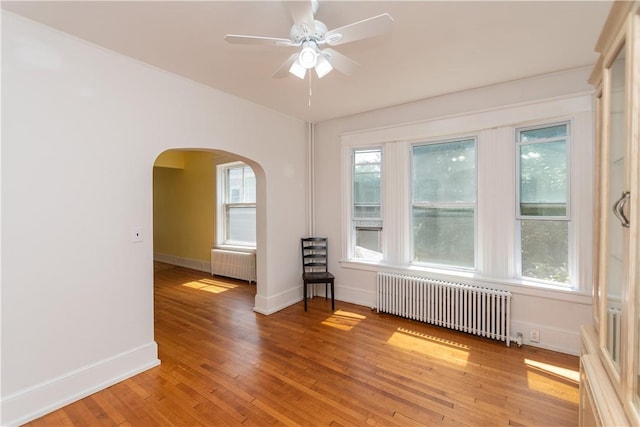 spare room with a wealth of natural light, light wood-type flooring, and radiator