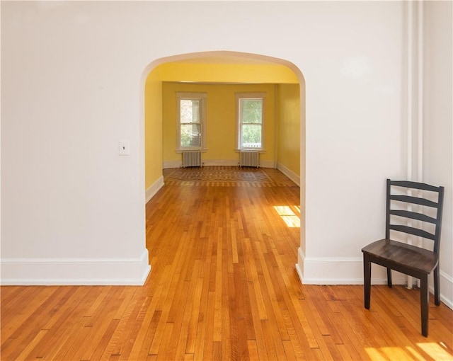 hall with light wood-type flooring and radiator heating unit