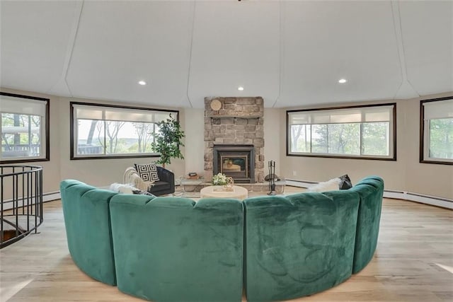 living room featuring plenty of natural light, a fireplace, and light hardwood / wood-style flooring