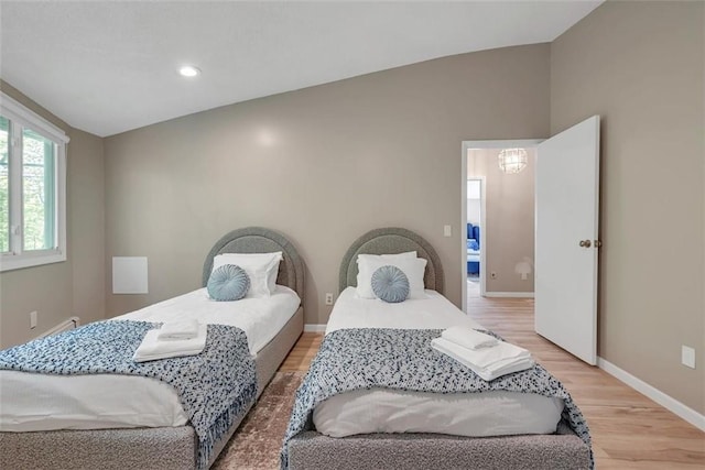 bedroom with light hardwood / wood-style floors and vaulted ceiling