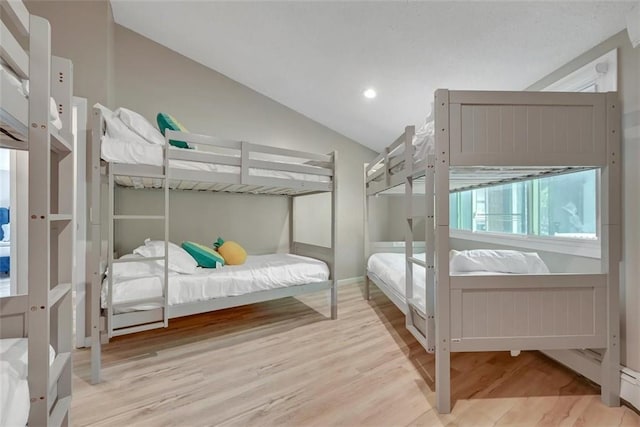 bedroom with vaulted ceiling and light wood-type flooring