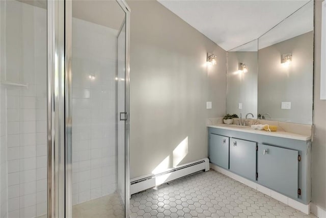 bathroom with tile patterned flooring, vanity, an enclosed shower, and a baseboard heating unit