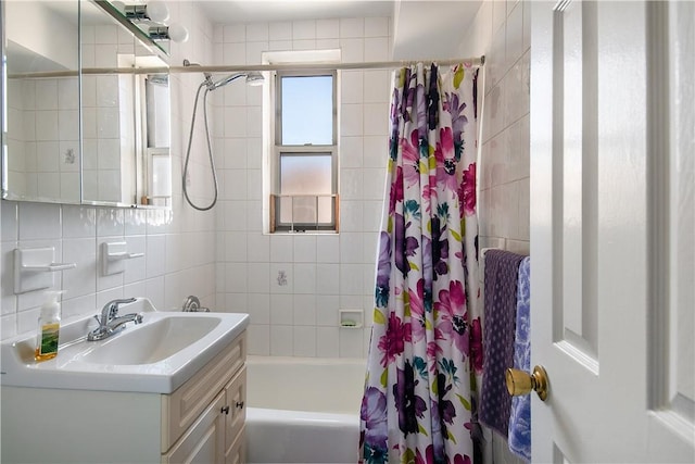 bathroom featuring vanity, backsplash, shower / bathtub combination with curtain, and tile walls