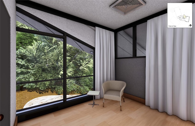 sitting room featuring a healthy amount of sunlight, wood-type flooring, and a textured ceiling