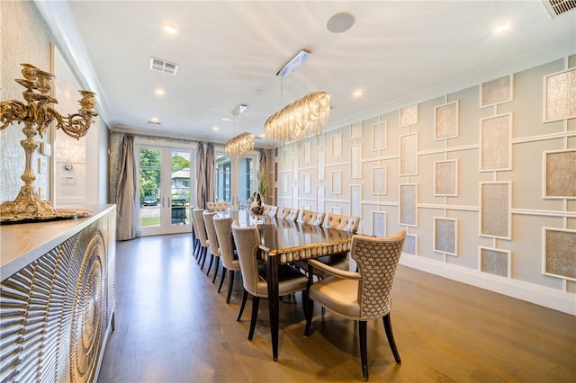 dining room with french doors, crown molding, dark wood-type flooring, and a notable chandelier