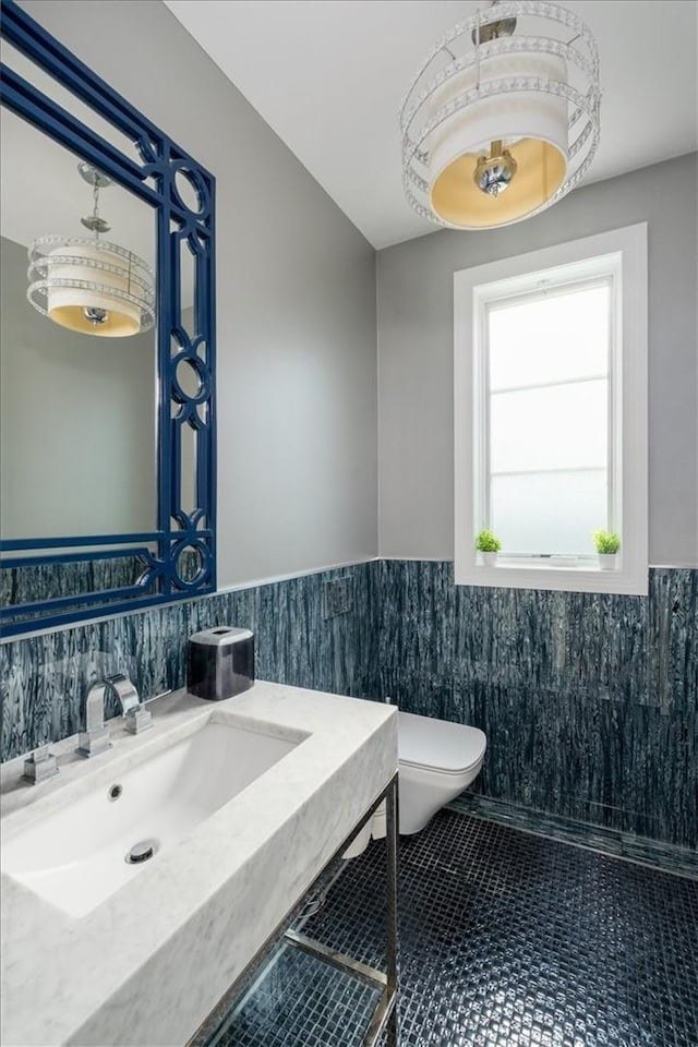 bathroom with sink, tile walls, and toilet