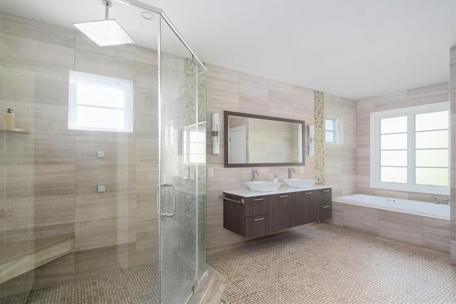 bathroom featuring tile patterned floors, vanity, independent shower and bath, and tile walls