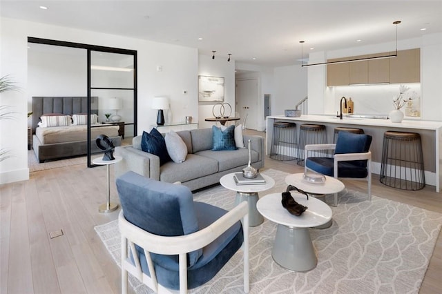 living room featuring sink and light hardwood / wood-style flooring