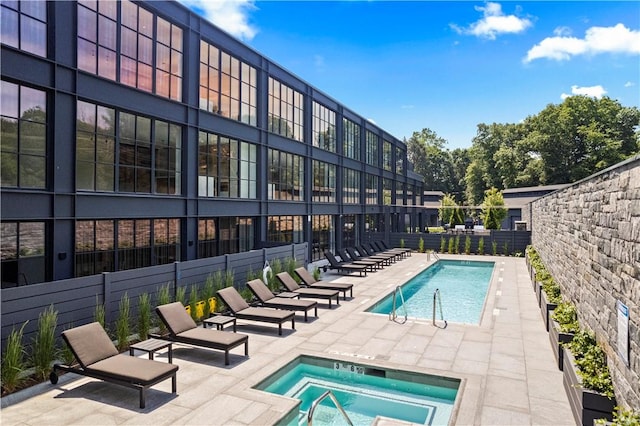 view of swimming pool featuring a patio area and a hot tub