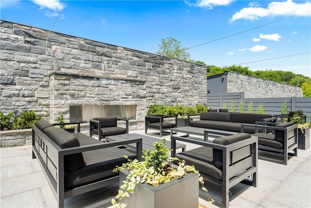 view of patio / terrace with an outdoor living space with a fireplace