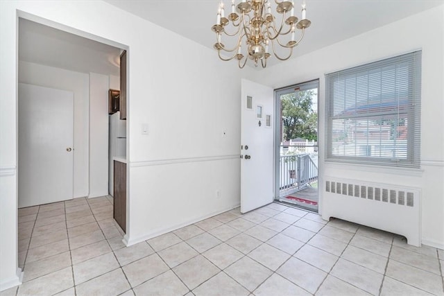 interior space featuring light tile patterned floors, radiator, and an inviting chandelier