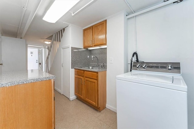 clothes washing area with cabinets, sink, and washer / clothes dryer