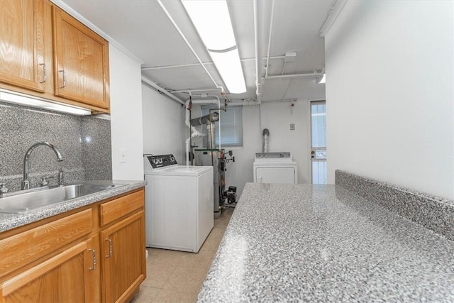 laundry room featuring separate washer and dryer, sink, and cabinets