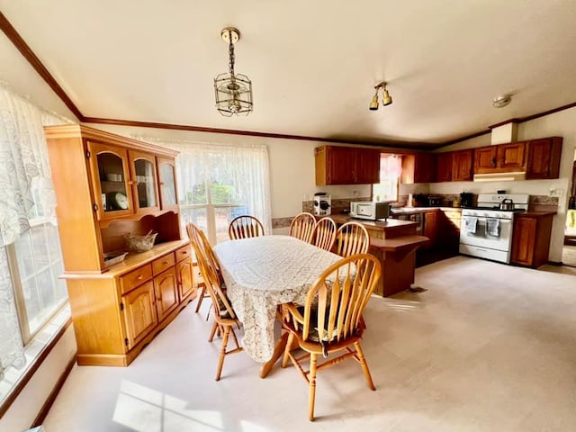 dining space with a chandelier, light carpet, vaulted ceiling, and ornamental molding