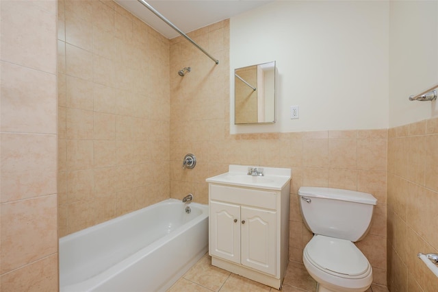 full bathroom with toilet, tile walls, tile patterned floors, tiled shower / bath, and vanity