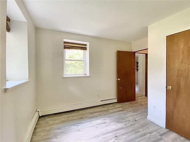 spare room with light hardwood / wood-style floors and a baseboard heating unit