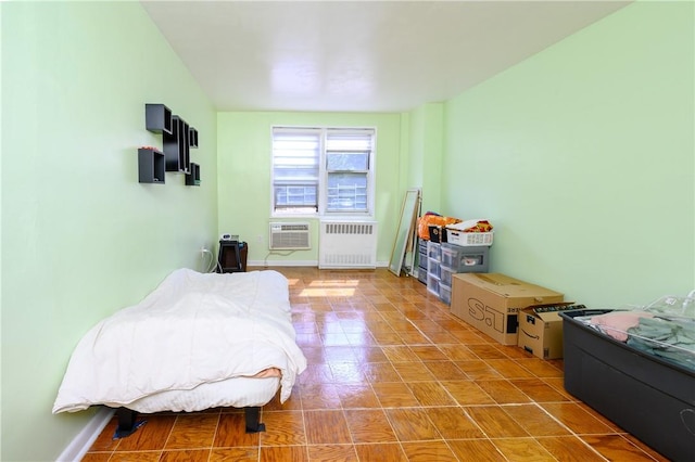 bedroom featuring a wall mounted AC and radiator heating unit