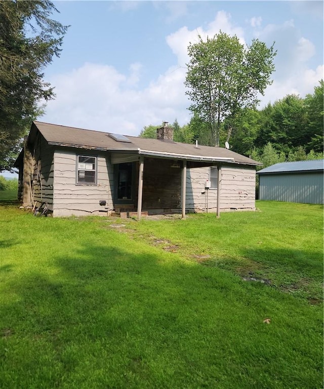 rear view of property with a lawn